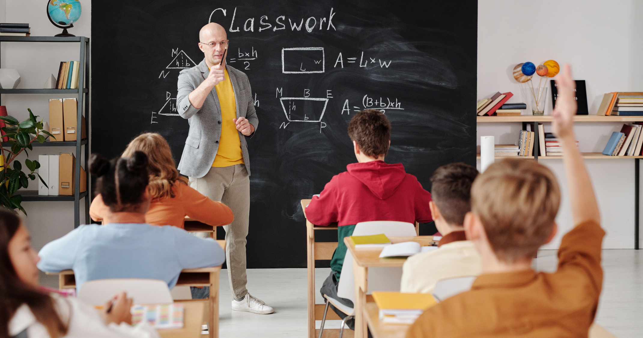 Teacher explaining a concept to students in a modern classroom using an e-learning portal for interactive online education.
